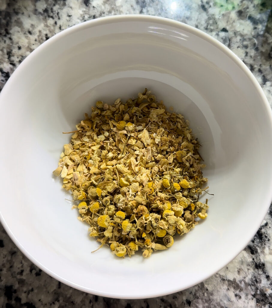 Loose leaf chamomile and ginger on white bowl