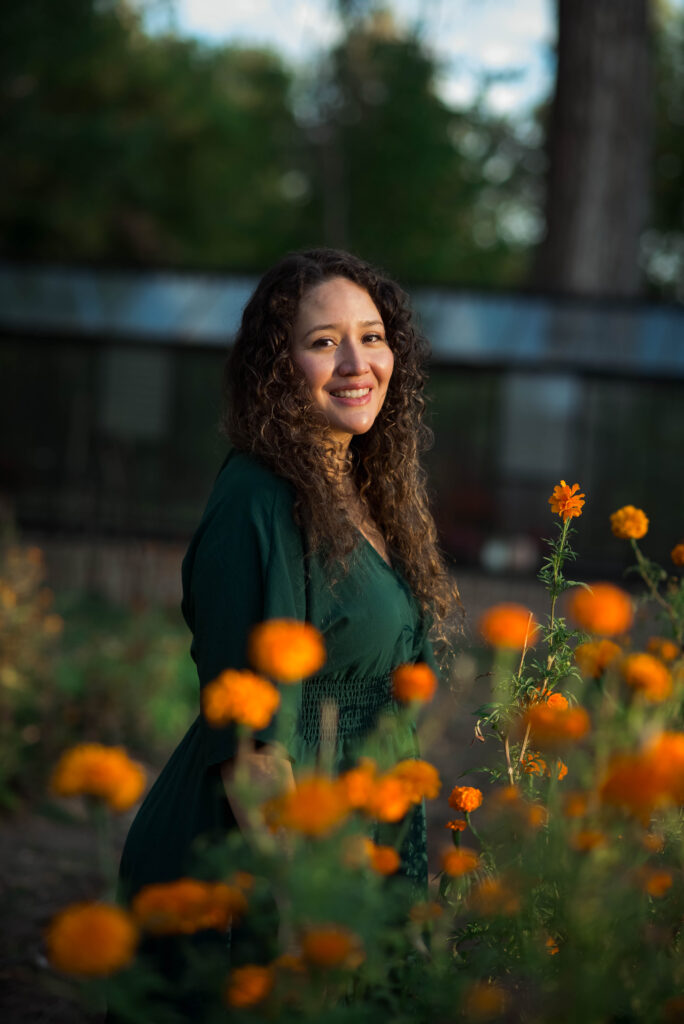 Woman standing behind a field of orange marigold flowers